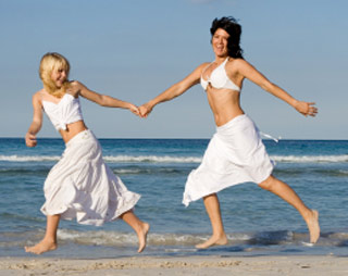 Mother and daughter happily running on beach