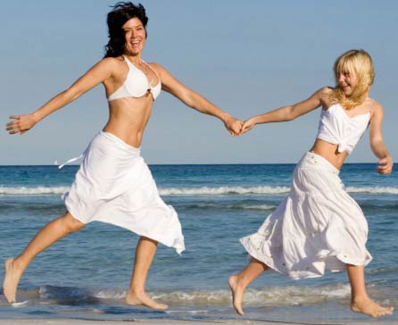 mother and daughter running on beach together